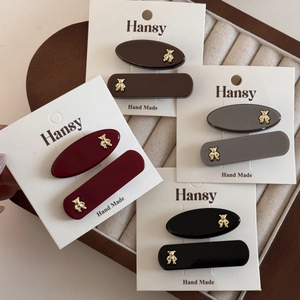 Set of four gold bear acetate hair clips in brown, red, grey, and black colors