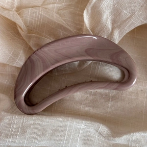 Detail of elegant Morandi pink marble texture hair claw clip on soft linen background