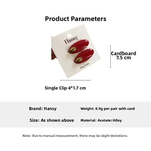 Detailed view of red oval acetate hair clips with gold label on branded card