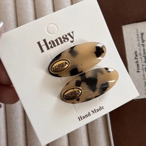 Detail of tortoise shell acetate oval hair clips with gold Korea label on branded card