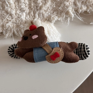 Detailed view of the brown corduroy bear hair claw clip with its blue vest and red bow