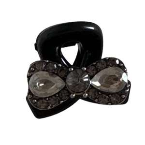 Elegant black bow hair claw clip with grey rhinestones and pearls on white background