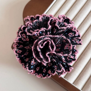 Détail de la pince à cheveux à fleurs avec bords au crochet roses et plis faits main