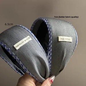 Close-up of handmade wide hairband with blue plaid piping and woven labels
