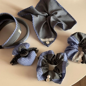 Detail showing grey scrunchie and hairband set with blue plaid trim and lace accents