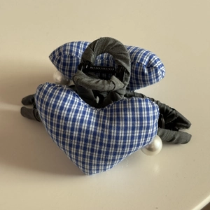 Detail of blue gingham fabric hearts with pearl beads on a grey cloth wrapped hair claw clip