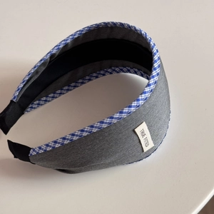 Detail of grey twill headband with blue plaid lace edge and white True Fitted logo label