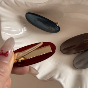 Detail showing the metal duckbill clip and France Handmade logo on oval hair clips