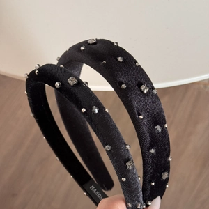Detailed side view of the black velvet padded headband with sparkling rhinestones and beads