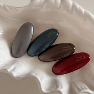 Set of four polished oval resin hair clips in classic deep colors with gold handmade text