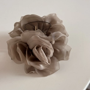 Détail d'une grande pince à cheveux fleur en organza de couleur moka élégante et chic