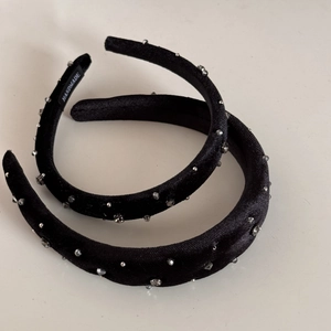 Close-up of black velvet headbands with sparkling rhinestones and handmade label