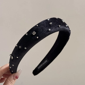 Detail of black velvet headband with sparkling rhinestones and handmade inner label