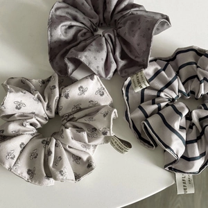 Detailed set of three silk-textured scrunchies with floral and striped patterns