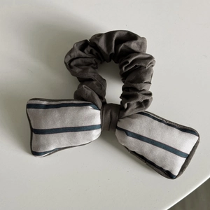 Detail of vintage ruffled hair scrunchie with grey striped bowknot accessory