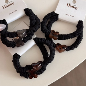 Elastic black scrunchies with tortoise shell heart and clover charms on display cards