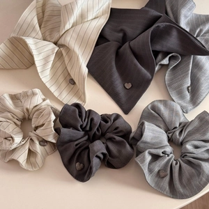 Detail view of large striped scrunchies and matching square scarves with heart metal charms