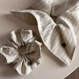 Detailed view of striped scrunchie and long ribbon with small black heart accents