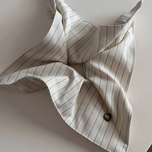 Detail of striped fabric scrunchie with a sparkling black heart-shaped diamond buckle