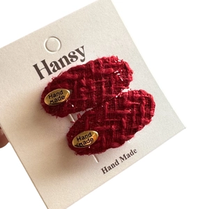Elegante rote Tweed-Haarspangen in Ovalform mit Gold-Metall-Tag auf weißer Karte
