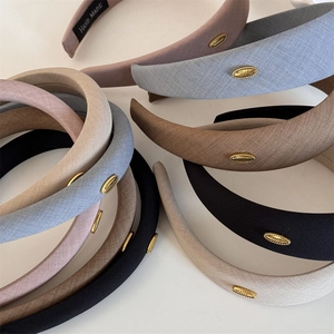Minimalist wide fabric headband for women featuring a gold label and soft sponge inner