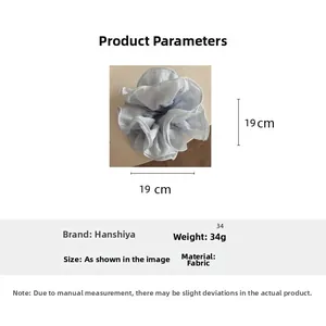 Detail view of a 19x19cm oversized light blue pleated fabric hair scrunchie with dimensions