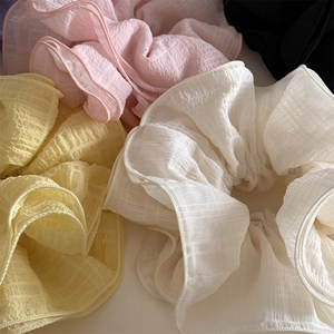 Close-up of pleated organza hair scrunchies with delicate ruffled texture and soft pastel colors