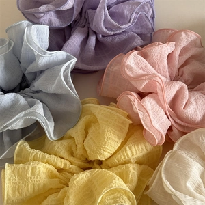 Macro detail of oversized pleated scrunchies in pastel macaron colors with plissé texture