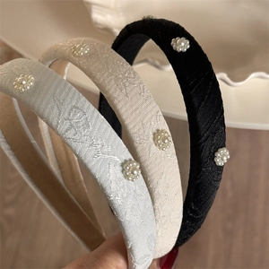 Close-up of padded headbands with elegant jacquard fabric and pearl flower accents