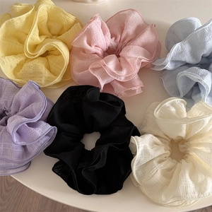 Detail of oversized organza scrunchies in six pastel colors with subtle plaid texture