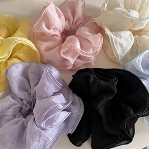 Flat lay of six colorful ruffled scrunchies with checkered texture on white background