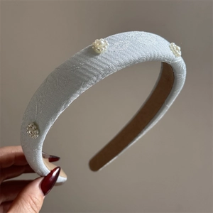Detail of embroidered floral sponge headband with pearls and light blue jacquard texture