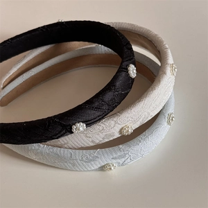 Detailed view of three sponge headbands with floral pearl embroidery and jacquard fabric