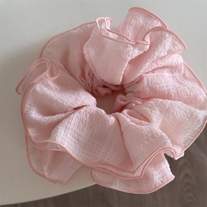 Close-up of pink seersucker oversized scrunchie with layered wavy ruffle details