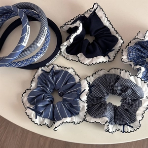 Detail of blue plaid and striped scrunchies with elegant bow ties and ruffled edges