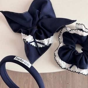 Detail view of navy blue plaid hair accessories set with headband and ribbon bow tie