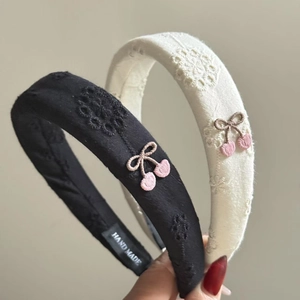Close-up of handmade hairbands with delicate cherry and lace floral embroidery details