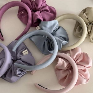 Close-up of colorful pleated sponge headbands with handmade labels in pastel colors