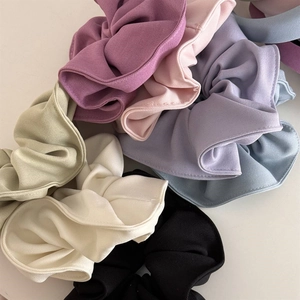 Close-up of colorful pleated scrunchies set in various pastel and vibrant fabric shades