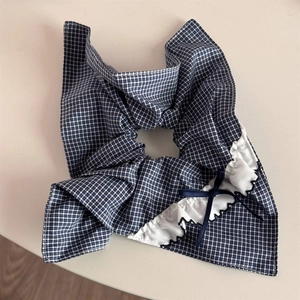 Detail of blue gingham scrunchie with white lace trim and dark blue ribbon bow