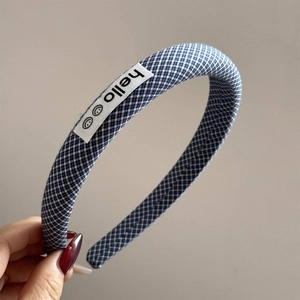 Close-up of blue gingham fabric headband with hello label and smiling face icons