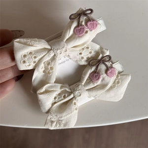 Detail of embroidered cherry lace bow hair clips with silver metal alligator clips