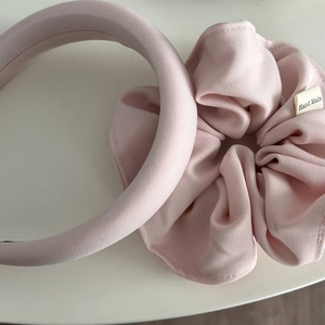 Macro shot of light pink twill cotton padded headband and scrunchie with handmade label
