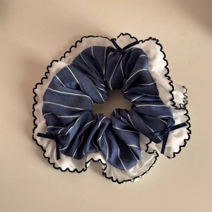 Detail of blue plaid scrunchie with white chiffon ruffles and small satin bows