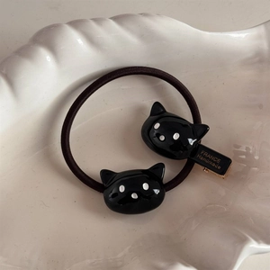 Détail de l'élastique chat noir et de la barrette fait main avec des pois blancs