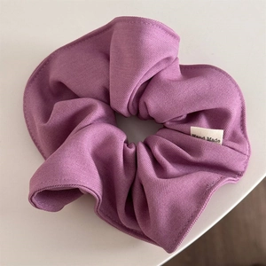 Detailed view of light purple scrunchie featuring twill texture and Hand Made label