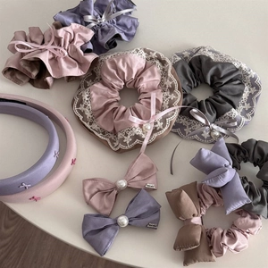 Close-up of luxury silk scrunchies and lace hair clips with elegant pearl details