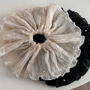 Detail von übergroßen Netz-Haargummis mit Kunstperlenverzierung in Schwarz und Weiß