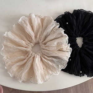 Detailansicht großer Haargummis in Schwarz und Beige mit eleganten Perlenverzierungen