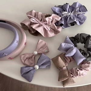 Close-up of Morandi pink and purple lace bow hair ties and satin scrunchies detail